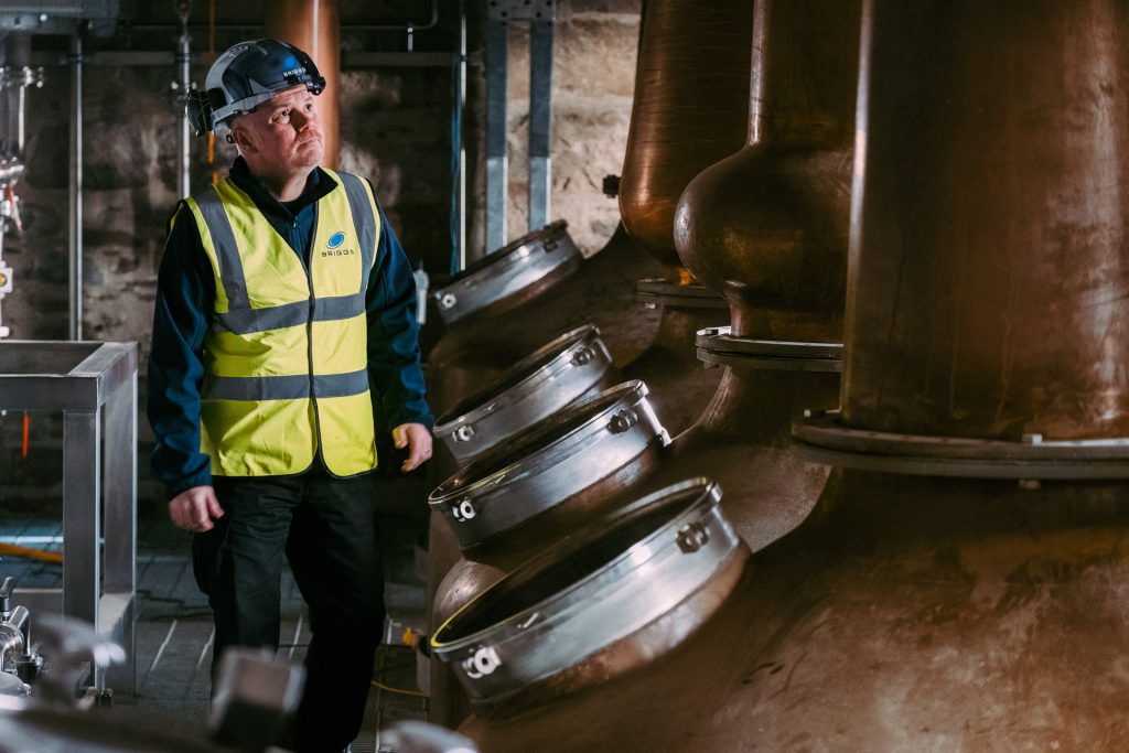 Man working on copper pot stills